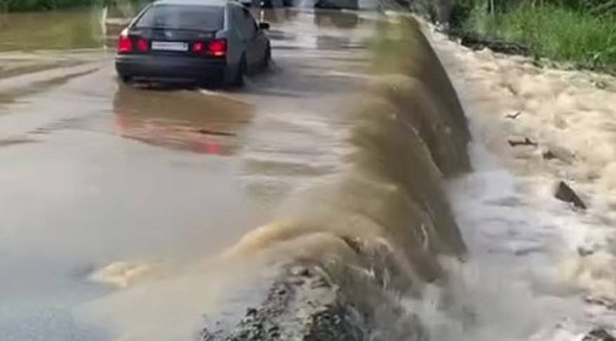 Водители преодолевают водопад на трассе в Приморье Водители преодолевают водопад на трассе в Приморье
